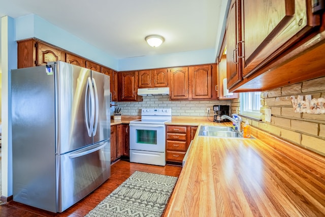 kitchen featuring brown cabinets, white range with electric cooktop, freestanding refrigerator, a sink, and under cabinet range hood