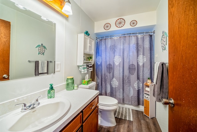 bathroom featuring a shower with shower curtain, vanity, toilet, and wood finished floors