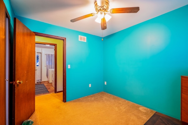 unfurnished bedroom featuring ceiling fan, visible vents, and carpet flooring