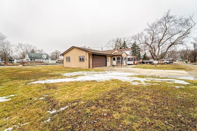 view of side of home with a garage, a yard, and concrete driveway