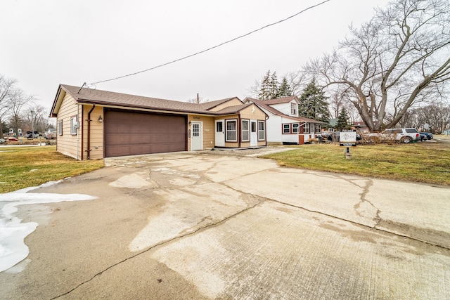 view of front facade featuring driveway, a front lawn, and an attached garage