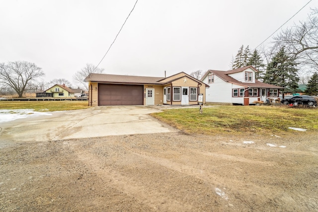 view of front of property featuring a garage, a front yard, and concrete driveway