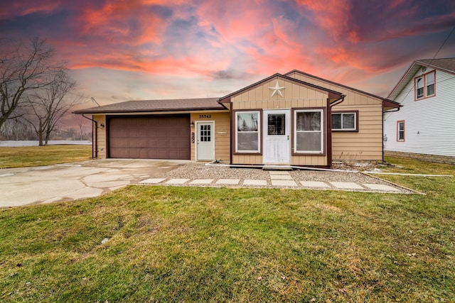 view of front facade featuring an attached garage, driveway, a front lawn, and board and batten siding