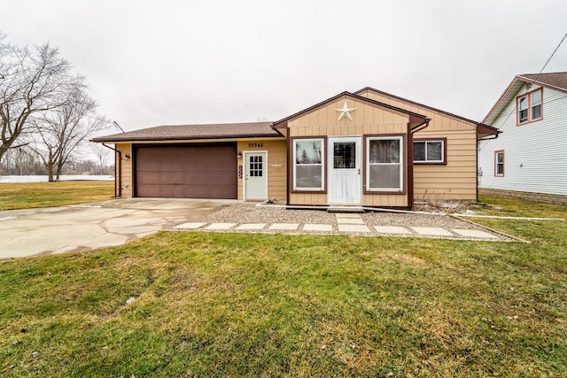 view of front facade featuring an attached garage, board and batten siding, concrete driveway, and a front yard