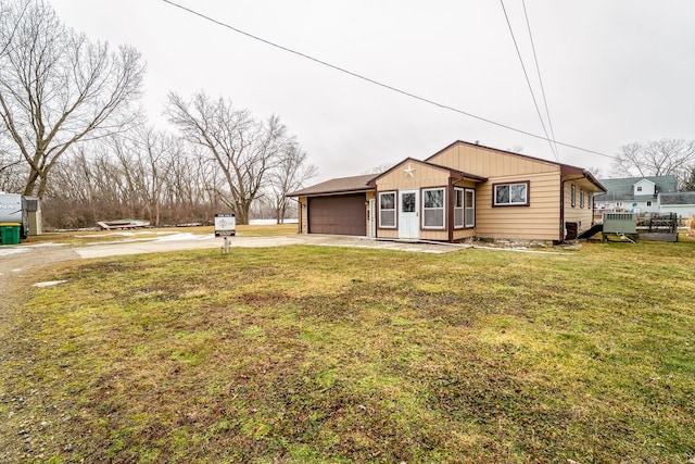 view of front of home with board and batten siding, an attached garage, driveway, and a front lawn