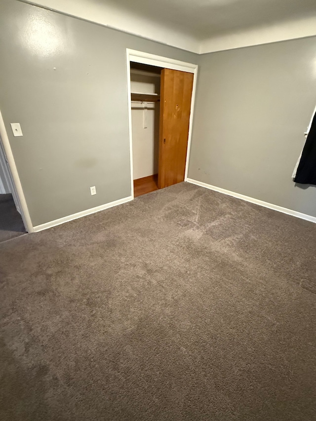 unfurnished bedroom with carpet, baseboards, and a closet