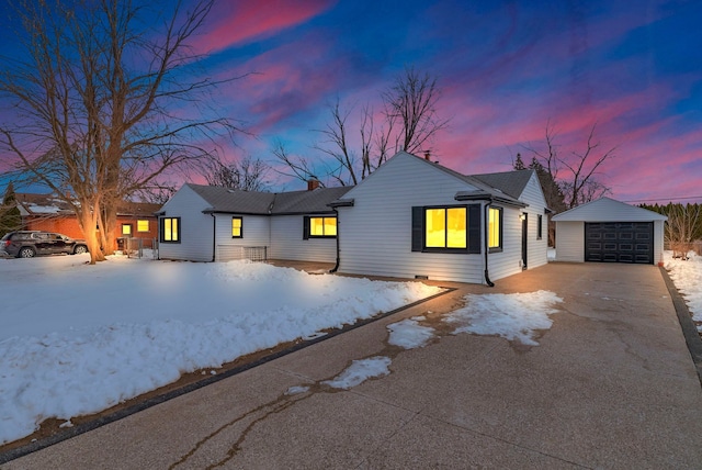 single story home with aphalt driveway, an outbuilding, and a detached garage