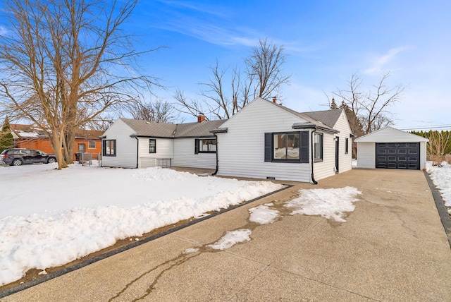 ranch-style house featuring an outbuilding, a chimney, a detached garage, and driveway