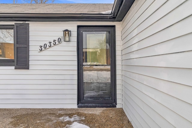 property entrance with a shingled roof