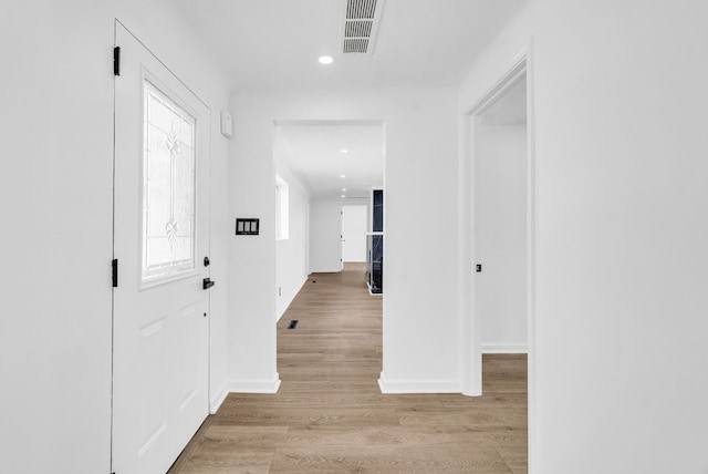 hall featuring recessed lighting, visible vents, light wood-style flooring, and baseboards