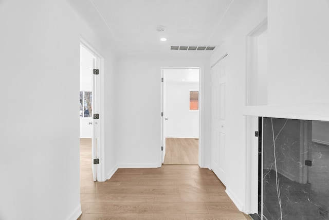 corridor with visible vents, baseboards, and wood finished floors