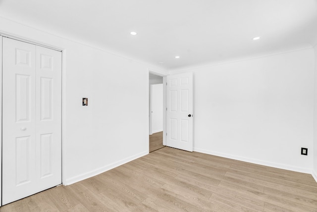 unfurnished bedroom with recessed lighting, a closet, light wood-style flooring, and baseboards