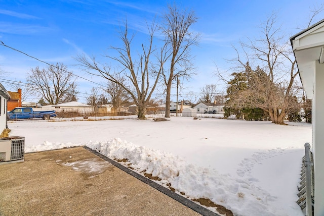 yard covered in snow with fence and central AC