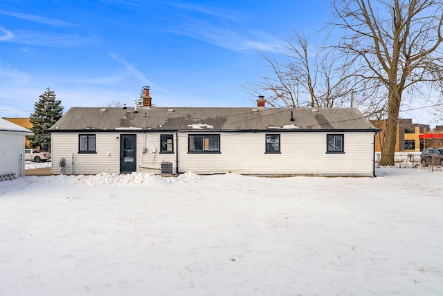 snow covered rear of property with central air condition unit