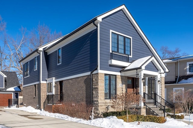 view of front of house featuring stone siding, an outbuilding, and brick siding