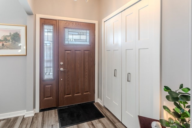 foyer entrance with baseboards and wood finished floors