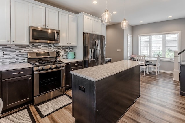 kitchen with white cabinetry, light wood-style flooring, tasteful backsplash, and appliances with stainless steel finishes