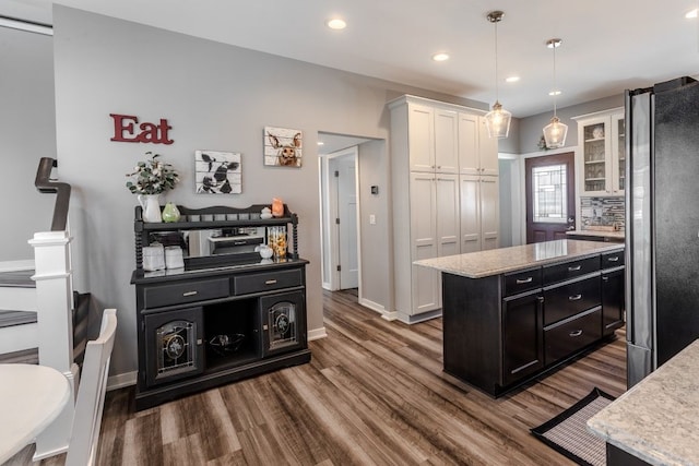 kitchen featuring white cabinets, dark cabinetry, freestanding refrigerator, and dark wood-type flooring