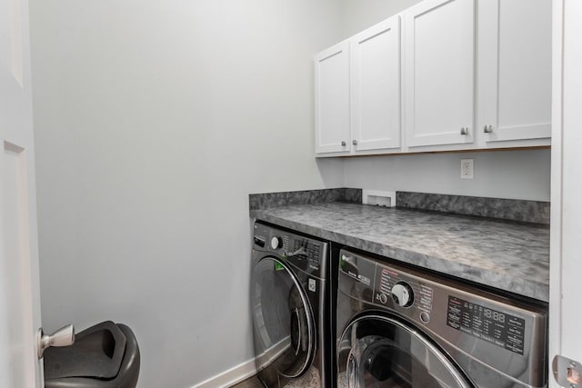 laundry room with washing machine and clothes dryer, cabinet space, and baseboards