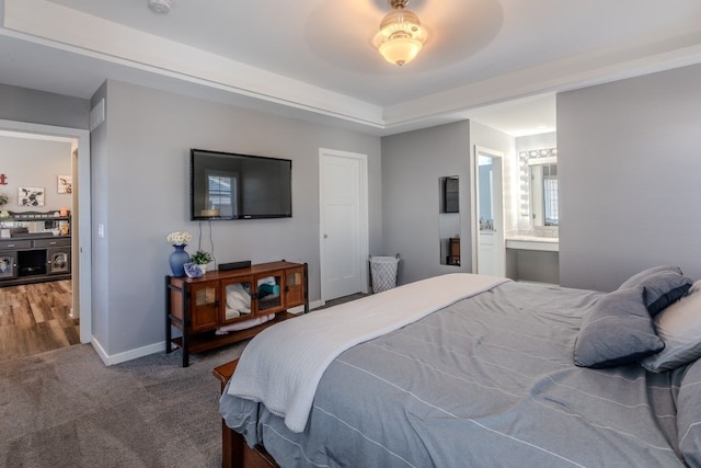 bedroom featuring carpet flooring, ensuite bath, baseboards, and a ceiling fan