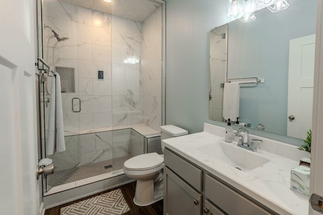 full bath with a stall shower, toilet, and vanity