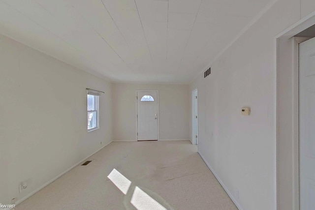 foyer with carpet floors and visible vents