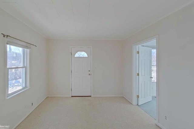 foyer entrance with carpet floors and baseboards