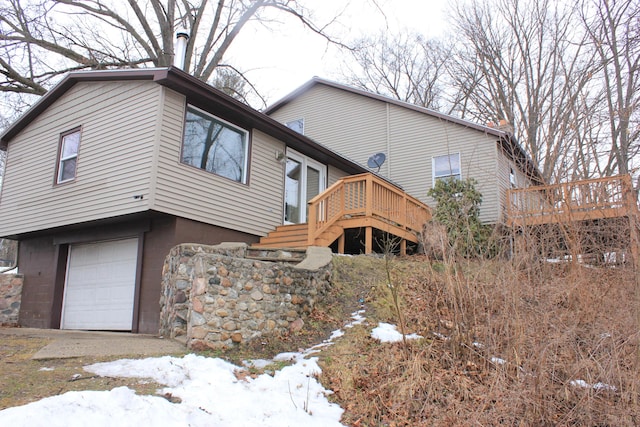 exterior space with a garage, a wooden deck, and stairs