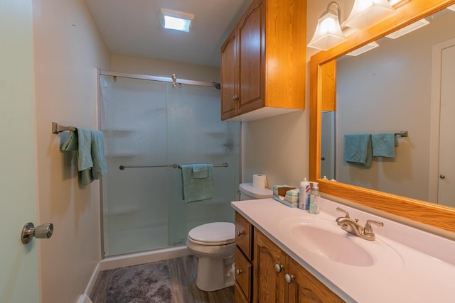 bathroom featuring a stall shower, vanity, and toilet