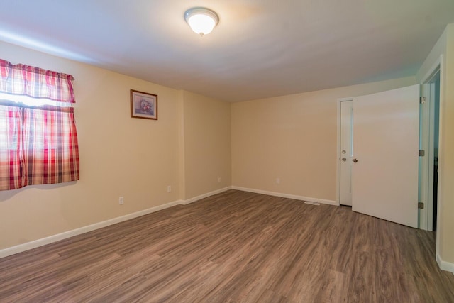 unfurnished room featuring wood finished floors and baseboards