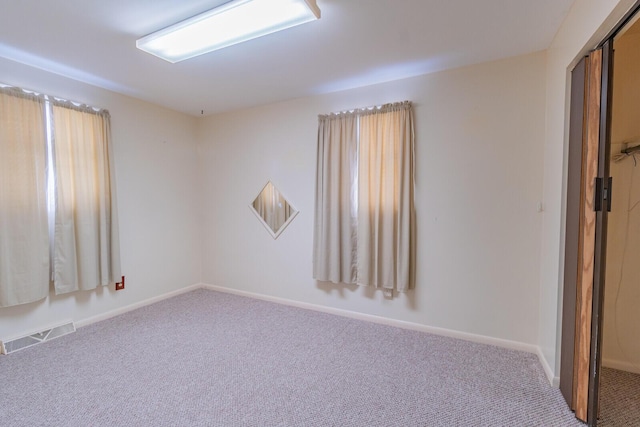 unfurnished room featuring baseboards, visible vents, and carpet flooring