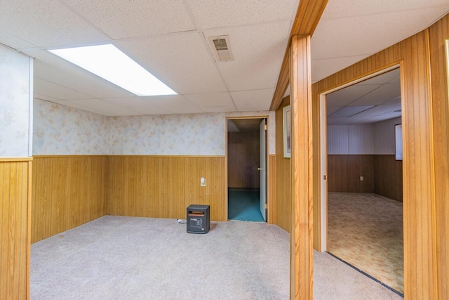 unfurnished room featuring a wainscoted wall, carpet floors, wood walls, and visible vents