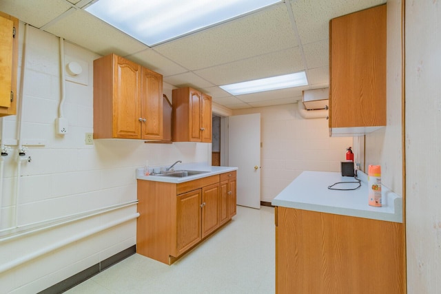 kitchen with light countertops, light floors, a sink, and brown cabinets