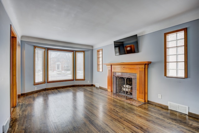 unfurnished living room featuring visible vents and wood finished floors