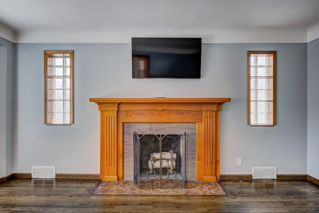 unfurnished living room with a wealth of natural light, a fireplace with flush hearth, and visible vents