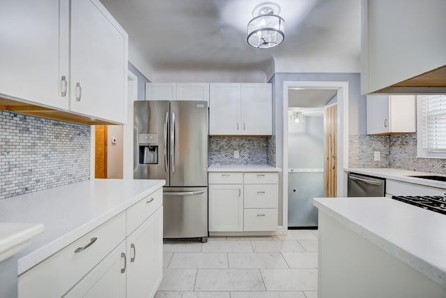 kitchen featuring appliances with stainless steel finishes, light countertops, decorative backsplash, and white cabinetry