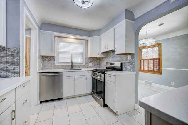 kitchen featuring stainless steel appliances, plenty of natural light, a sink, and light countertops