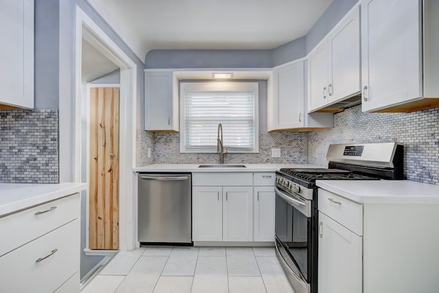 kitchen featuring stainless steel appliances, light countertops, decorative backsplash, white cabinets, and a sink