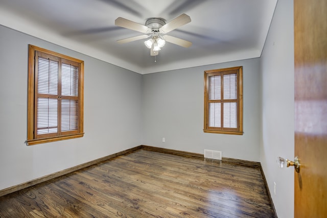 empty room featuring baseboards, visible vents, ceiling fan, and wood finished floors