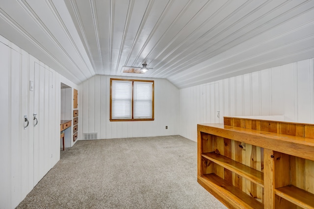 additional living space with lofted ceiling, carpet flooring, and visible vents