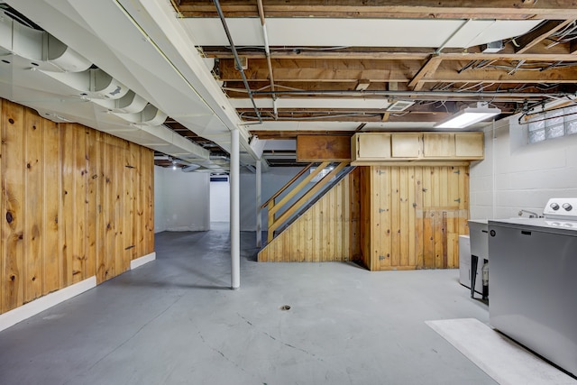 below grade area with fridge, wooden walls, and washer / clothes dryer