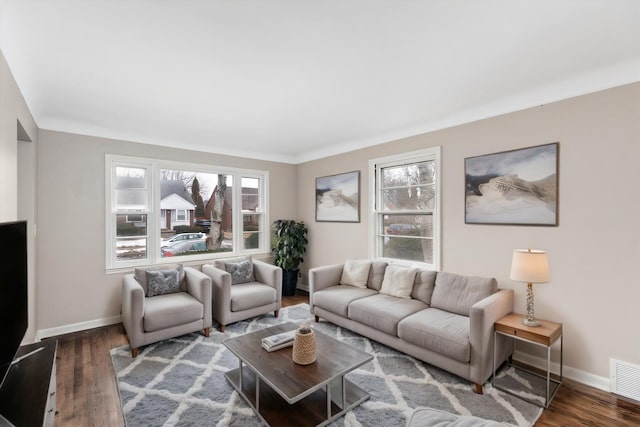 living room featuring dark wood-style floors, a wealth of natural light, and baseboards