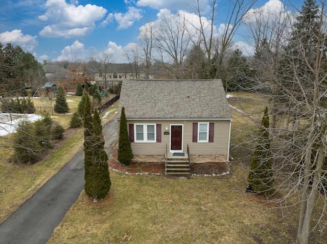 view of front of house featuring a front lawn, roof with shingles, driveway, and entry steps