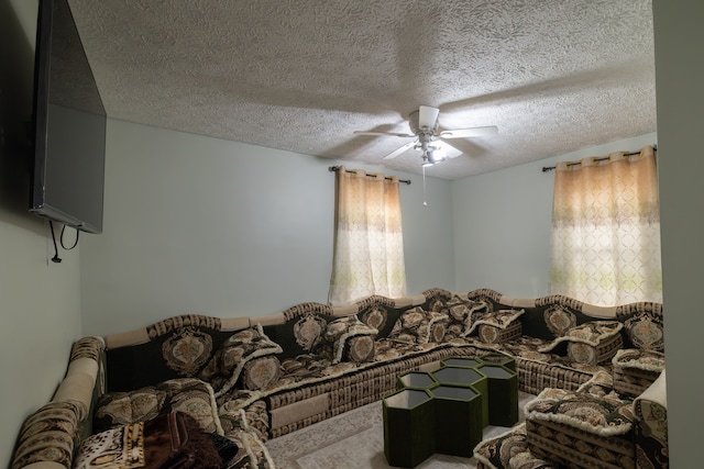 living area featuring a textured ceiling and a ceiling fan