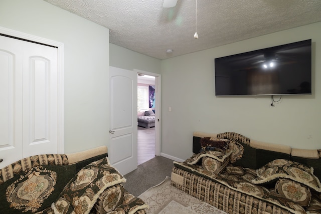 carpeted bedroom featuring baseboards, a textured ceiling, and ceiling fan