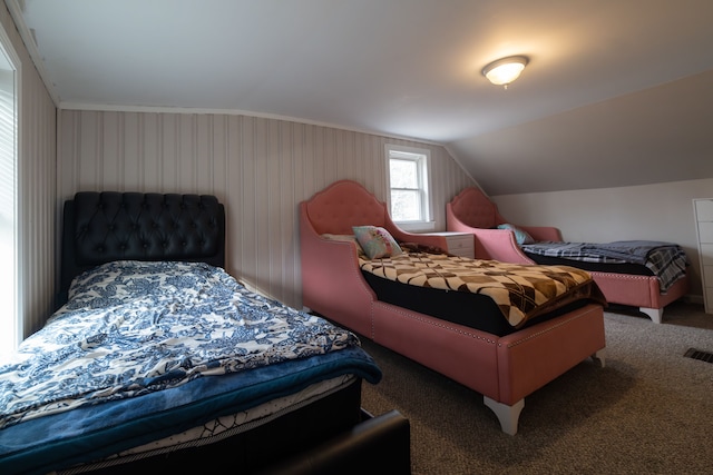 carpeted bedroom with visible vents and vaulted ceiling