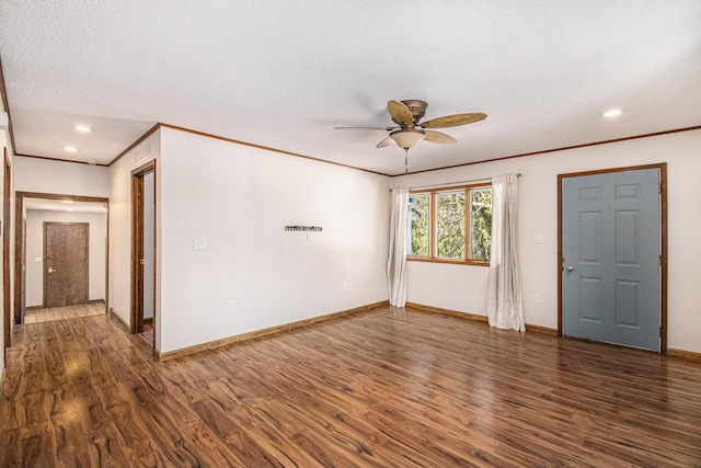 empty room featuring ornamental molding, wood finished floors, a ceiling fan, and baseboards