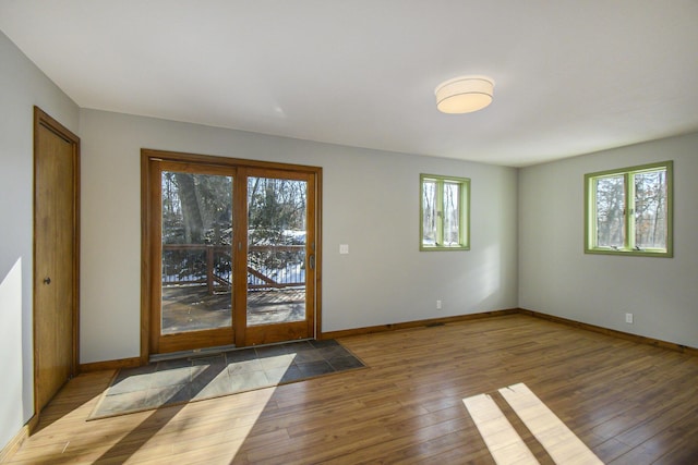 doorway to outside with wood-type flooring and baseboards