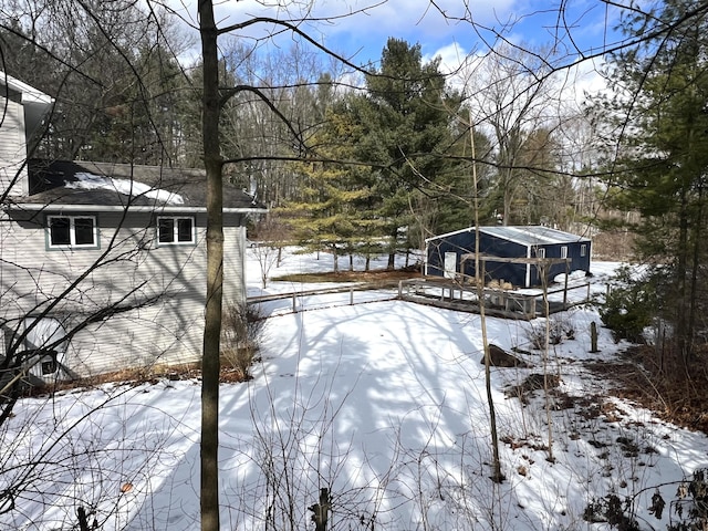 yard layered in snow featuring an outbuilding