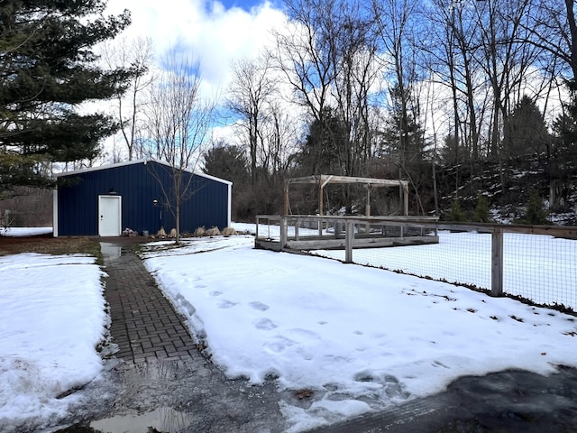 snowy yard featuring an outbuilding